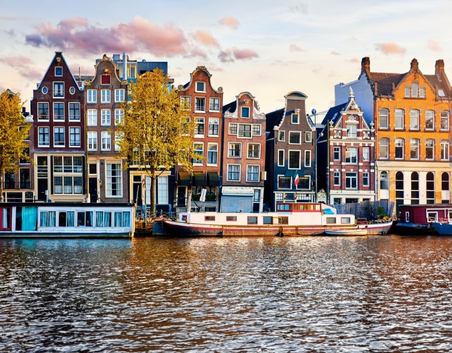Captivating view of Amsterdam's leaning houses along a picturesque canal, a memorable stop on your MSC Cruises journey. 