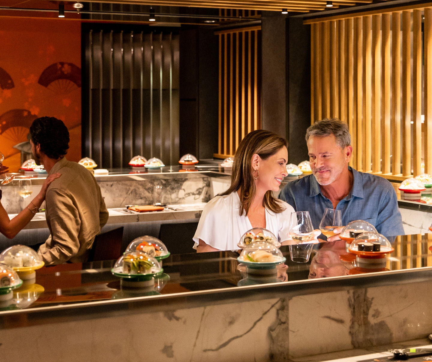 An image of a couple delighting in an a la carte sushi dining experience at the premium dining venue in the MSC Yacht Club, savoring a delectable selection of sushi dishes.